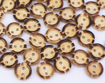 May include: A collection of wooden buttons with two holes and a dark brown rim. The buttons are scattered on a white surface.