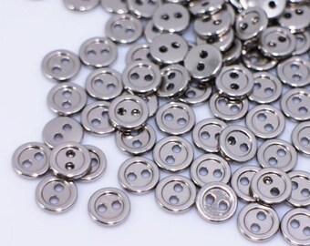 May include: A large pile of silver-toned two-hole buttons.
