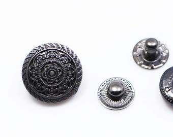 May include: Four metal buttons in different styles. Two are round with a decorative design, one is round with a hole in the center, and one is a round button with a raised center.