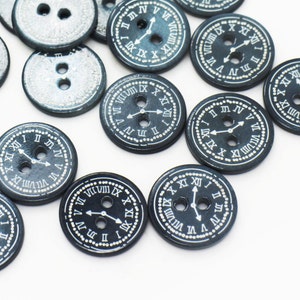 May include: A collection of black wooden buttons with a white clock face design. The buttons feature Roman numerals and hands.