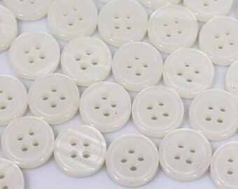 May include: A large group of white, round, four-hole buttons.