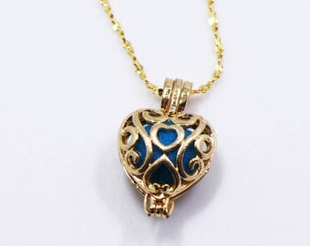May include: A gold chain necklace with a blue heart-shaped pendant. The pendant is made of delicate filigree metalwork.