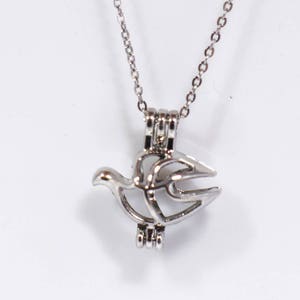 May include: Silver necklace with a dove-shaped cage pendant. The cage is open and ready to hold a pearl or other small charm.