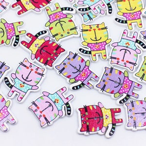 May include: Assortment of colorful wooden cat buttons with various patterns and designs. The buttons are painted with bright colors and have a whimsical look.
