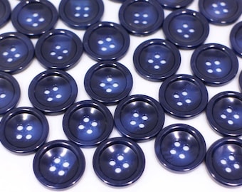 May include: A collection of dark blue plastic buttons with four holes each. The buttons have a slightly raised, shiny finish.
