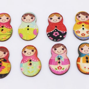 May include: Eight wooden buttons with a colorful, whimsical design of Russian nesting dolls. Each button features a different pattern and color scheme, including red, pink, yellow, green, and blue.
