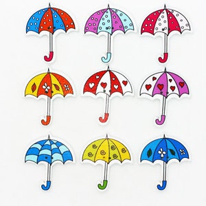 May include: Nine wooden buttons shaped like umbrellas with different colourful patterns. The patterns include polka dots, hearts, flowers and swirls.