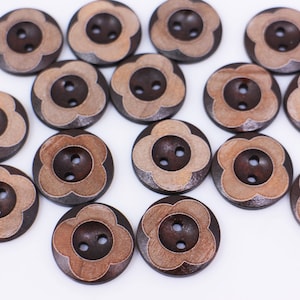 May include: A collection of 15 brown wooden buttons with a light brown flower design. Each button has two holes.