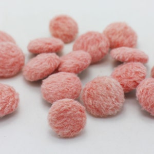 May include: A collection of pink fluffy buttons. The buttons are round and have a soft, plush texture.