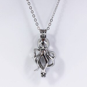 May include: Silver octopus charm necklace with a delicate chain. The charm is open and can be used to hold a small object, such as a pearl or a crystal.
