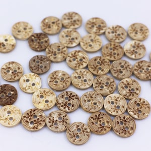 May include: A collection of round, wooden buttons with a floral design. The buttons are in shades of brown and beige.