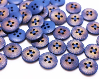 May include: A collection of blue wooden buttons with a gold floral design. The buttons have four holes each.