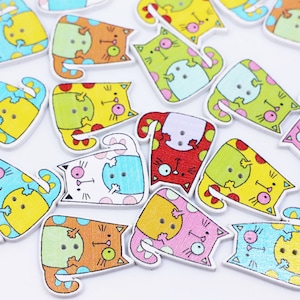 May include: Assortment of colorful wooden cat buttons with various patterns and designs. The buttons are approximately 1 inch in size and have two holes for sewing.