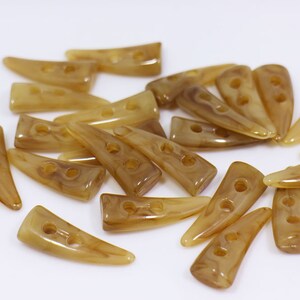 May include: A group of 20 brown plastic buttons with two holes each. The buttons are shaped like a pointed horn and have a marbled pattern.