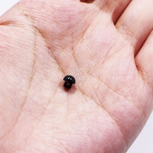 以下が含まれることがあります： 金属製のシャンクが付いた小さな黒いプラスチックボタン