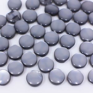 May include: A collection of round, gray buttons. The buttons are smooth and have a slight sheen.