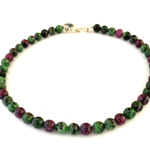 Könnte beinhalten: Eine Halskette aus grünen und rosafarbenen Edelsteinen mit einem silbernen Verschluss. Die Halskette besteht aus runden Perlen und ist etwa 45 cm lang.