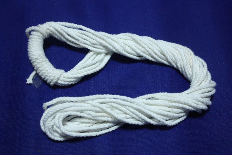 K&ouml;nnte beinhalten: Ein wei&szlig;es Baumwollseil, das auf einer blauen Oberfl&auml;che aufgerollt ist. Das Seil ist etwa 3 Meter lang.