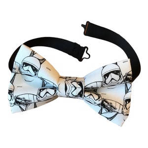 May include: White bow tie with a black and white print of Stormtrooper helmets from Star Wars.