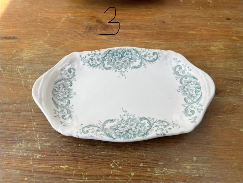 May include: White ceramic serving platter with a teal floral pattern. The platter is rectangular with curved edges. The floral design is concentrated around the edges and centre of the platter. The number 3 is written on the top.