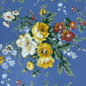 May include: A blue floral fabric with a repeating pattern of yellow, white, and red flowers. The flowers are surrounded by green leaves.