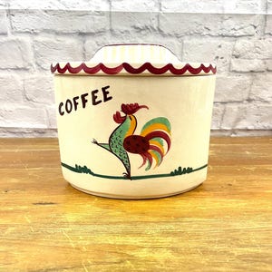 May include: White ceramic coffee canister with a red rooster design and the word "COFFEE" in red lettering.