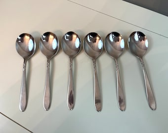 May include: Six silver soup spoons with ornate handles.