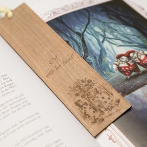 May include: A wooden bookmark with a laser-engraved image of a scene from Alice in Wonderland. The bookmark features the text "Elf with her head!"