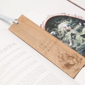 May include: A wooden bookmark with a light brown finish. The bookmark features an engraved image of a rabbit and the text "Oh dear! Oh dear! I shall be late!"