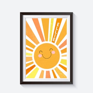May include: A framed print featuring a yellow sun with a smiling face and orange and yellow rays. The name "ELLIE" is written vertically in the top right corner of the print.