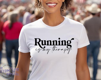 May include: White t-shirt with black text that reads "Running is my therapy".