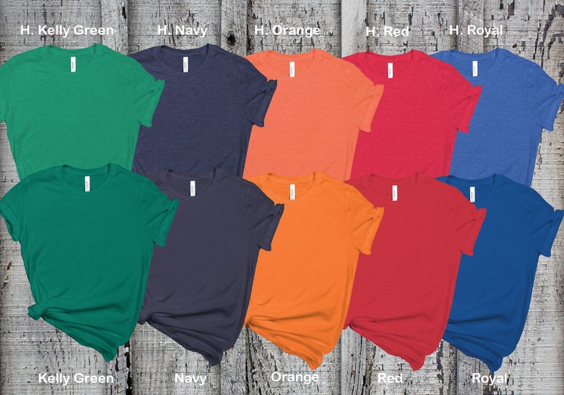May include: Ten blank t-shirts in various colors, including kelly green, navy, orange, red, and royal blue. The shirts are laid out on a wooden surface.