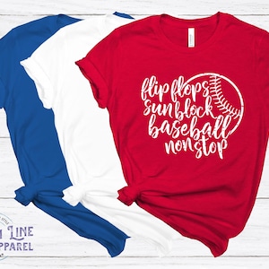 May include: Three t-shirts in red, white, and blue. The red t-shirt has a white graphic that says "flip flops sunblock baseball nonstop" with a baseball graphic.