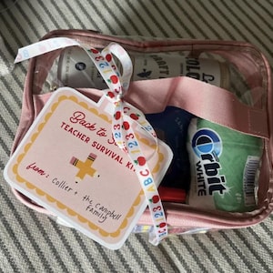 K&ouml;nnte beinhalten: Eine rosa, transparente Rei&szlig;verschlusstasche gef&uuml;llt mit verschiedenen Artikeln, darunter eine Kaffeekanne und Orbit-Kaugummi. Ein Geschenkanh&auml;nger mit dem Text "Back to School Teacher Survival Kit" ist mit einem Band befestigt.