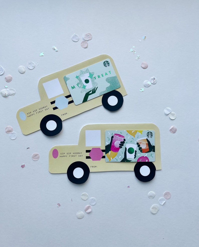 May include: Two yellow school bus-shaped gift cards with a green and white Starbucks gift card on the top card and a green and white Starbucks gift card with three cups of coffee on the bottom card. The text on the top card reads "My Treat" and the text on the bottom card reads "Sip Sip Hooray Happy First Day".