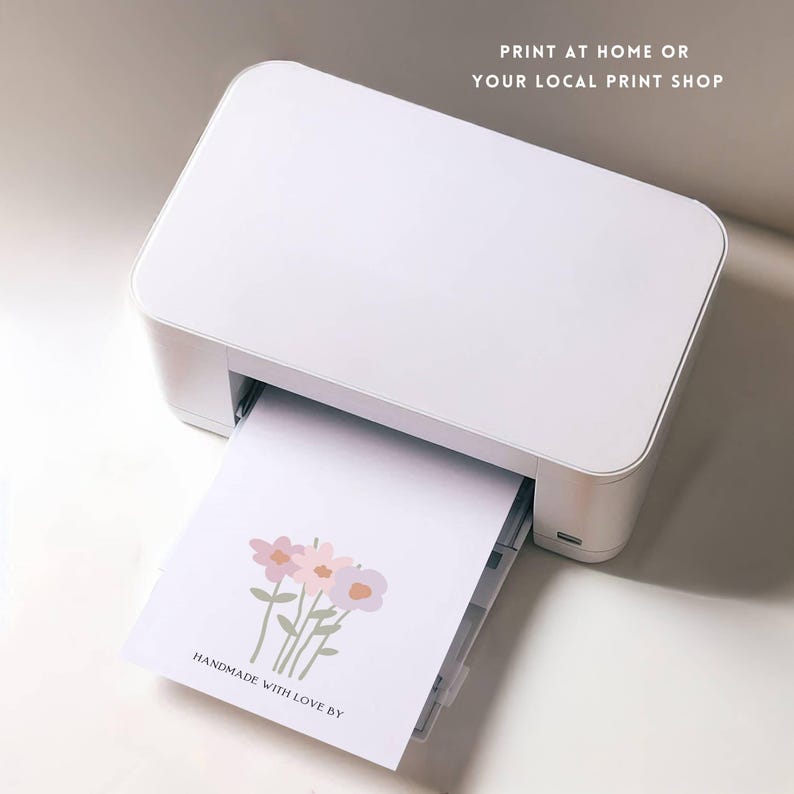 May include: A white printer with a sheet of paper coming out of it. The paper has a simple illustration of three pink and purple flowers with green stems. The text "HANDMADE WITH LOVE BY" is printed at the bottom of the page.