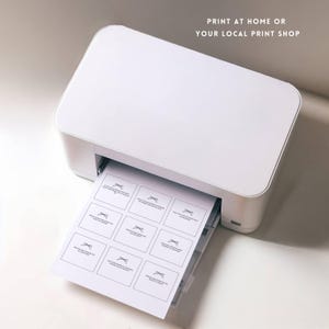 May include: A white printer with a sheet of paper coming out of the tray. The paper has a grid of 12 squares with a simple design in each square. The text "PRINT AT HOME OR YOUR LOCAL PRINT SHOP" is at the top of the image.