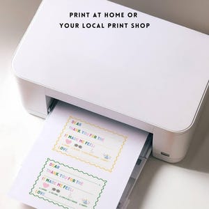 May include: A white printer printing sheets of paper with colorful text and designs. The text on the paper reads "DEAR THANK YOU FOR THE IT MADE ME FEEL LOVE". The image also includes the text "PRINT AT HOME OR YOUR LOCAL PRINT SHOP".
