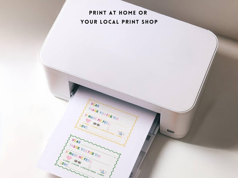 May include: A white printer printing sheets of paper with colorful text and designs. The text on the paper reads "DEAR THANK YOU FOR THE IT MADE ME FEEL LOVE". The image also includes the text "PRINT AT HOME OR YOUR LOCAL PRINT SHOP".