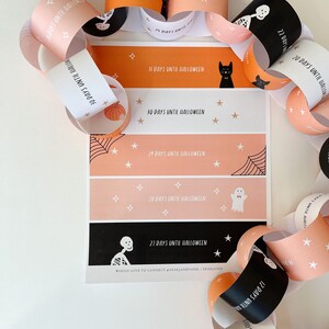 May include: A printable Halloween countdown chain with orange and pink paper links. Each link features a different Halloween character and the number of days until Halloween. The text on the chain reads "Days Until Halloween".