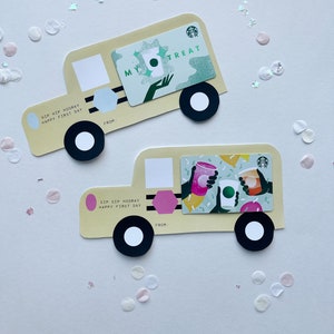 May include: Two yellow paper cut-out trucks with black wheels. The top truck has a green gift card with the text "My Treat" and a green Starbucks logo. The bottom truck has a pink gift card with the text "Sip Sip Hooray Happy First Day".