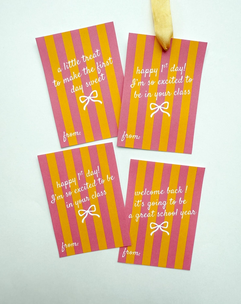 Pu&ograve; includere: Quattro etichette regalo rettangolari con strisce verticali rosa e arancioni. Ogni etichetta ha testo bianco e una grafica a fiocco. Le etichette recitano: "a little treat to make the first day sweet", "happy 1st day!"