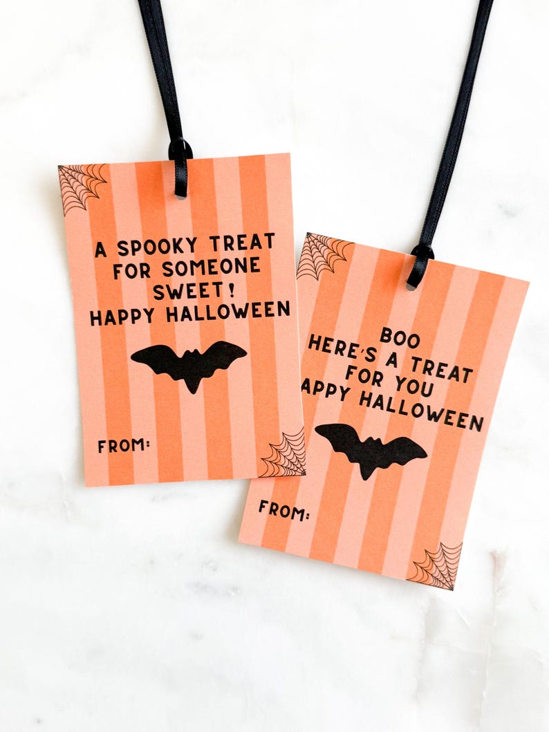 May include: Two Halloween gift tags with orange and pink stripes, black bat silhouettes, and the phrases "A Spooky Treat" and "Here's a Treat." Each tag has a black ribbon and a "From:" line.