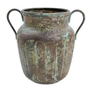 May include: A bronze-coloured vase with two curved handles. The vase has a textured surface with vertical grooves and areas of blue-green patina. The vessel has a wide body and a slightly flared rim, suitable for home decor.