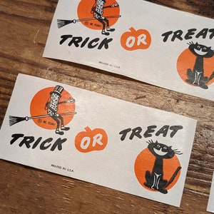 K&ouml;nnte beinhalten: Halloween-Aufkleber mit Mr. Peanut auf einem Besen, einem K&uuml;rbis und einer schwarzen Katze. Die Worte "Trick or Treat" sind in Schwarz gedruckt. Gedruckt in den USA.