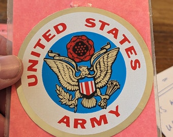 May include: A gold sticker with a blue circle and a white eagle with a red, white, and blue shield. The eagle is holding a bundle of arrows in its right talon and an olive branch in its left talon. The words "United States Army" are printed around the circle.