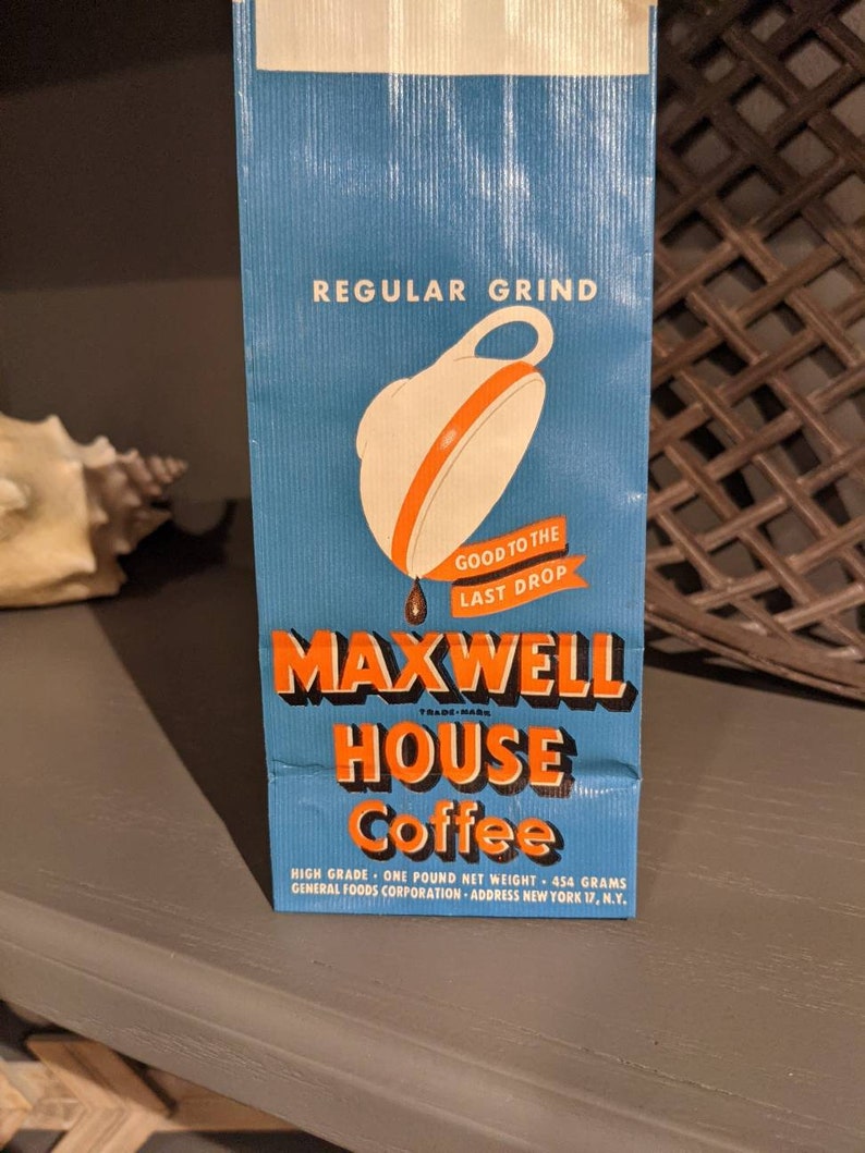 May include: A blue and orange vintage coffee bag with the text "REGULAR GRIND" and "MAXWELL HOUSE Coffee" printed on it. The bag also features a white coffee pot with an orange lid and a drop of coffee dripping from the spout. The text "GOOD TO THE LAST DROP" is printed below the coffee pot.