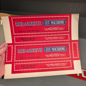 以下が含まれることがあります： レッド＆ホワイトブランドのカットマカロニ用の、ビンテージな赤と白の段ボール箱2つ。箱は赤色の背景に白い文字と青い縁取りが施されています。箱の文字は「Red & White Cut Macaroni」と「Chain Red & White Stores Ltd.」です。