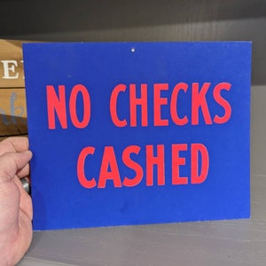 Cartel original de los años 50 que prohíbe el cobro de cheques