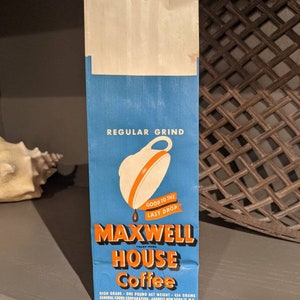 May include: A blue and orange paper bag with the text "Maxwell House Coffee" and the tagline "Good to the Last Drop". The bag is for a one-pound bag of regular grind coffee.